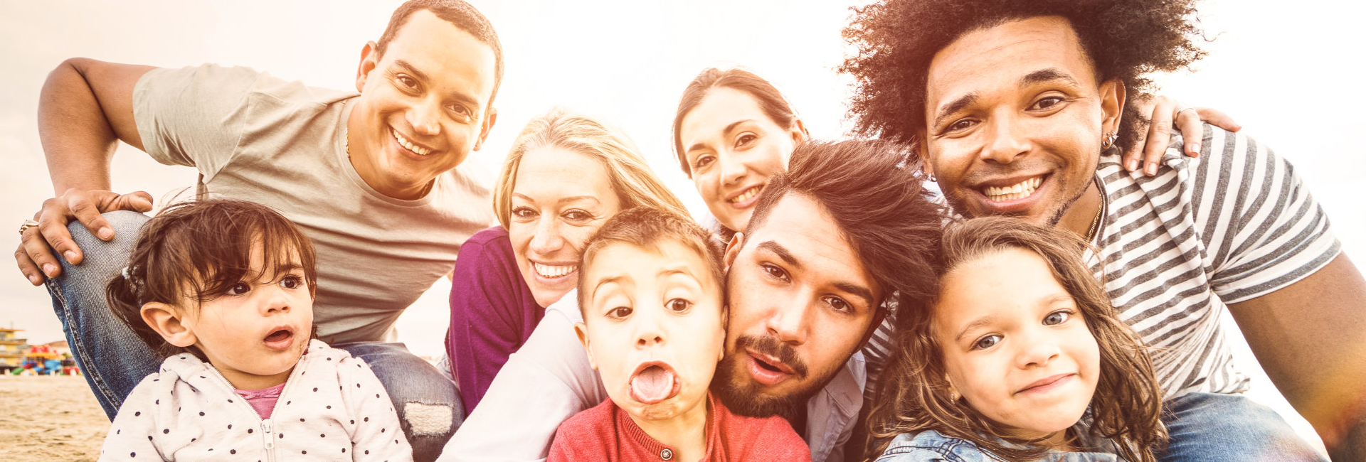 Happy multiracial families taking selfie at beach making funny faces